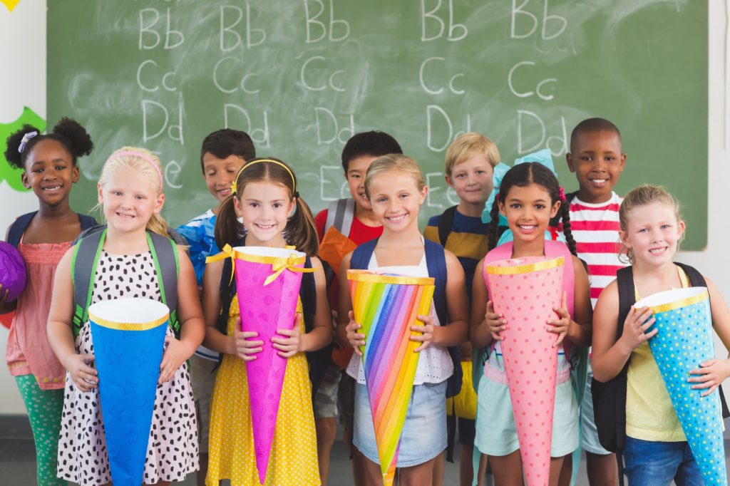 Happy kids holding gifts in classroom